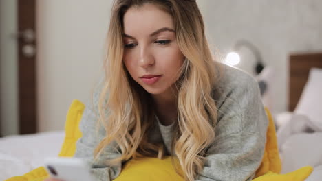 woman using smartphone in bed