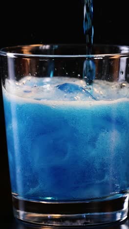 pouring and settling of a blue fizzy drink