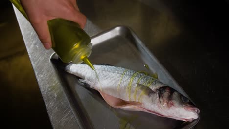 chef vierte aceite en pescado crudo