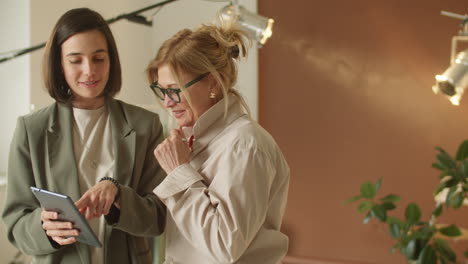 Mixed-Age-Female-Colleagues-Using-Tablet-and-Chatting-at-Work