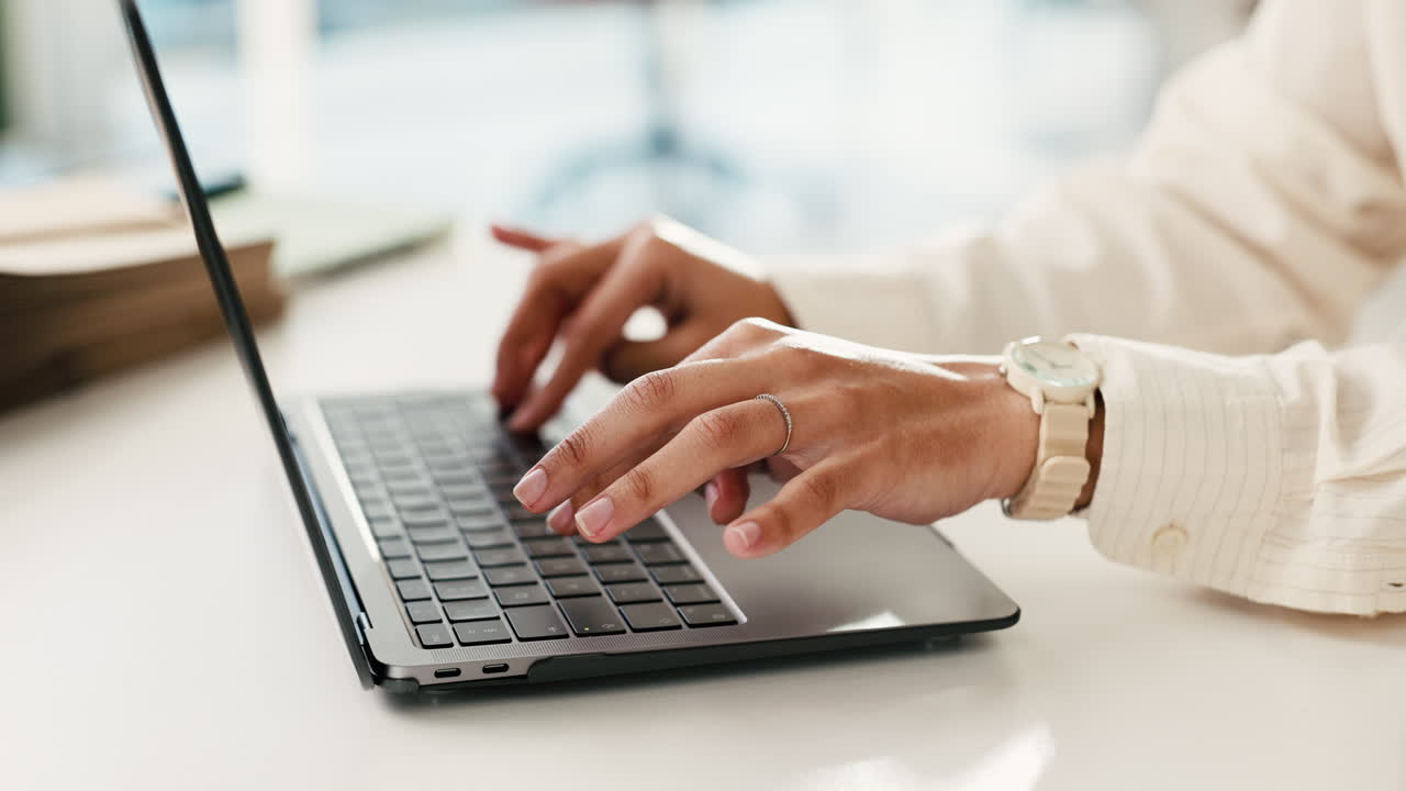 Close Up of Hands Typing on Laptop Keyboard in Office