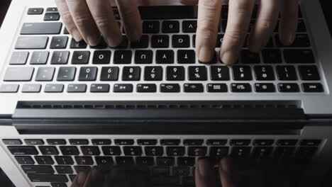 overhead view of laptop keyboard and fingers