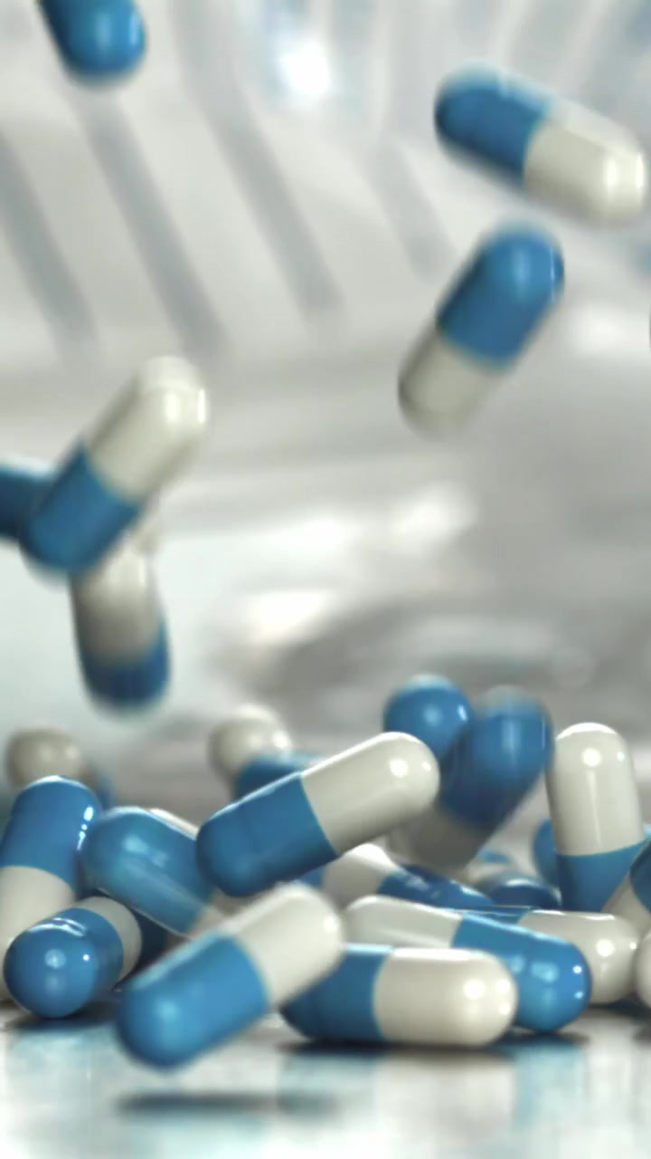 Capsule mediche blu e bianche che cadono al rallentatore