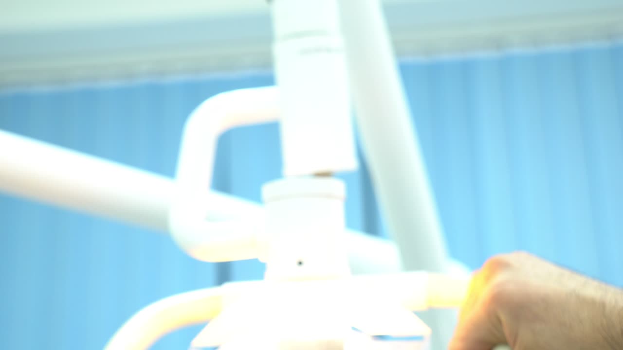 Dentista che regola la luce dentale.