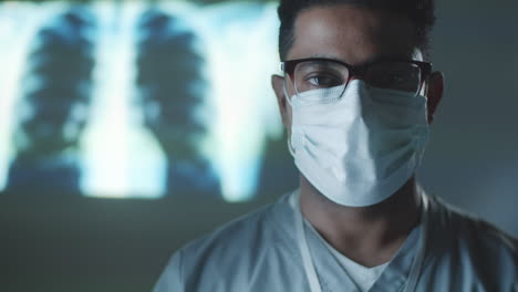 portrait of middle eastern doctor in mask in dark room