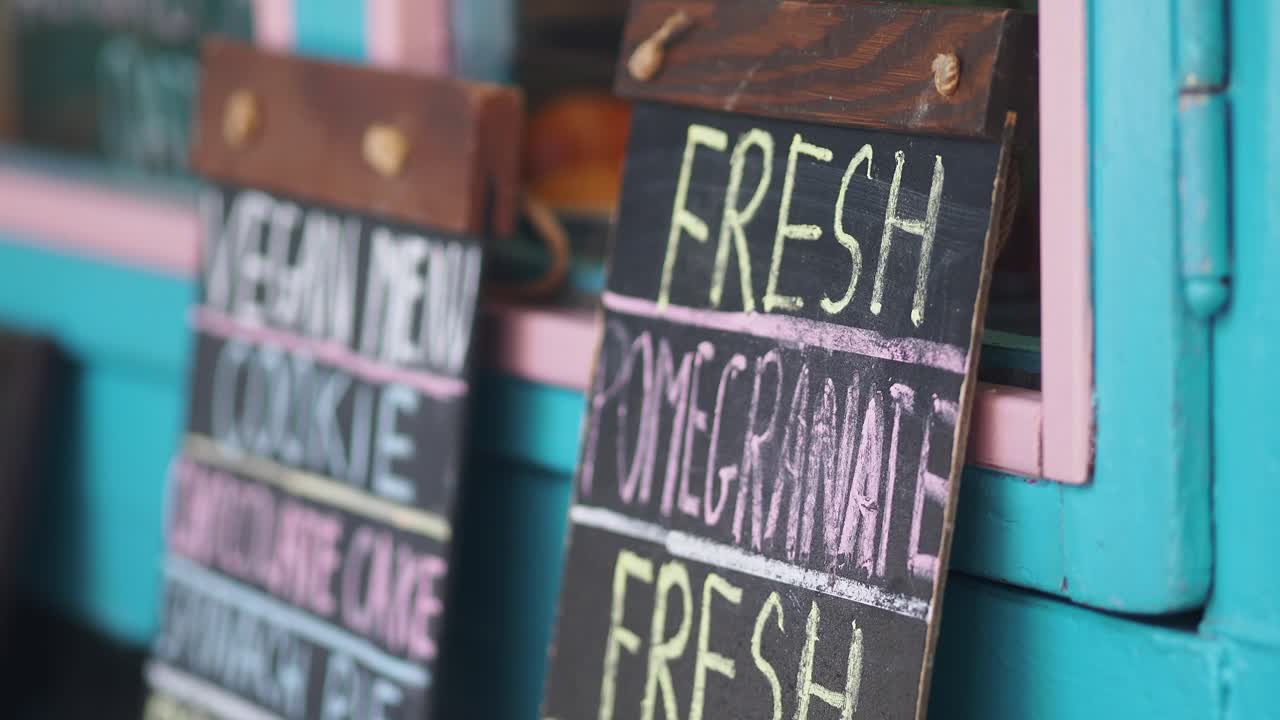 Nærbillede af rustik kridttavlemenu i et cafévindue
