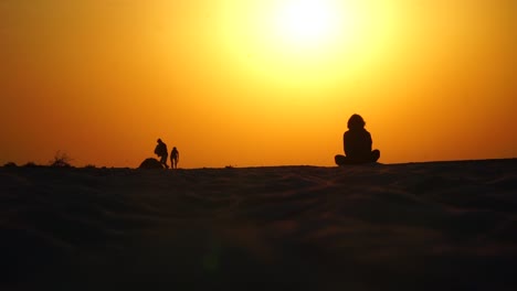 girl sitting on the beach in lotus position at sinrise