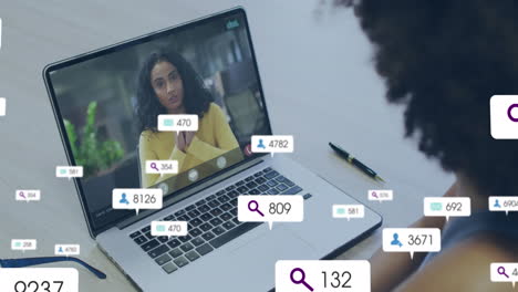Animation-Von-Social-Media-Symbolen-Und-Daten-über-Einer-Afroamerikanischen-Frau-Per-Laptop-Videoanruf