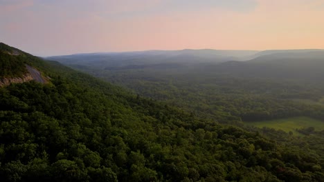 aerial drone video footage of a golden hour summer sunset in a green, vibrant rural appalachian mountain valley with beautiful light. in particular, this is in new york's hudson valley