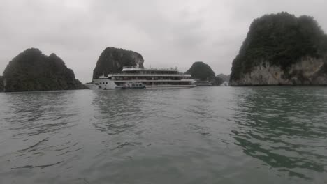 a cruise ship and island within the stunning halong bay in vietnam, captured using a gopro from a kayak