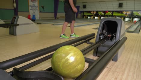 El-Hombre-Camina-Casualmente-Y-Lanza-Una-Pelota-Naranja-En-Una-Bolera-Retro,-Derriba-Un-Alfiler