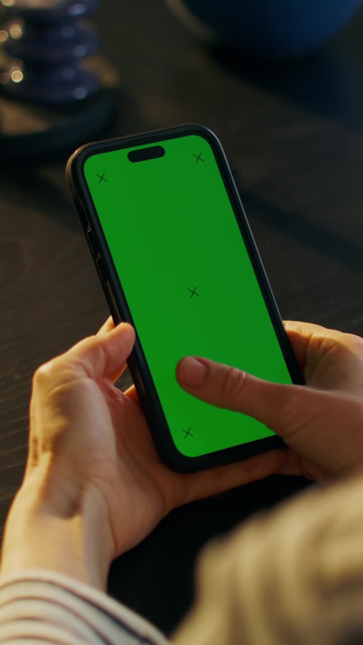 persona que sostiene un teléfono inteligente con una pantalla verde