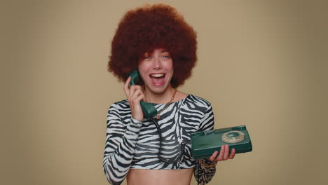 Pretty-woman-with-brown-lush-wig-talking-on-wired-vintage-telephone-of-80s-says-hey-you-call-me-back