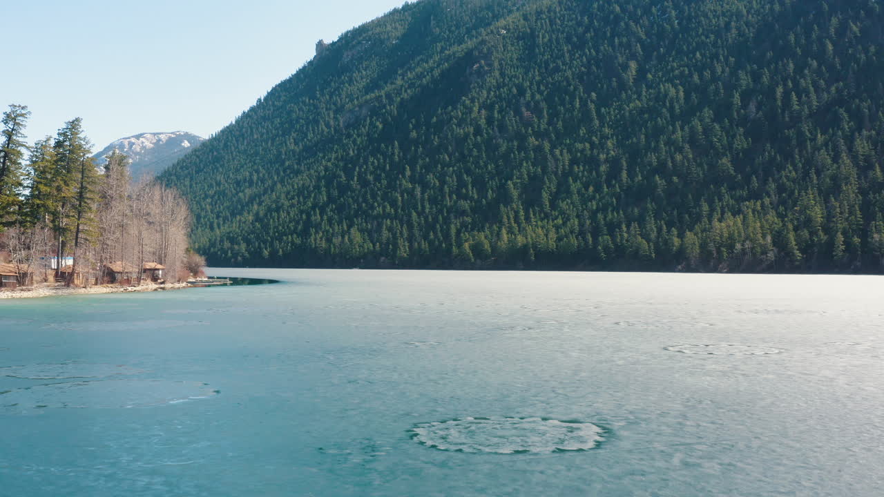 воздушный полет над красивым замерзшим голубым озером с интересными круговыми узорами на льду