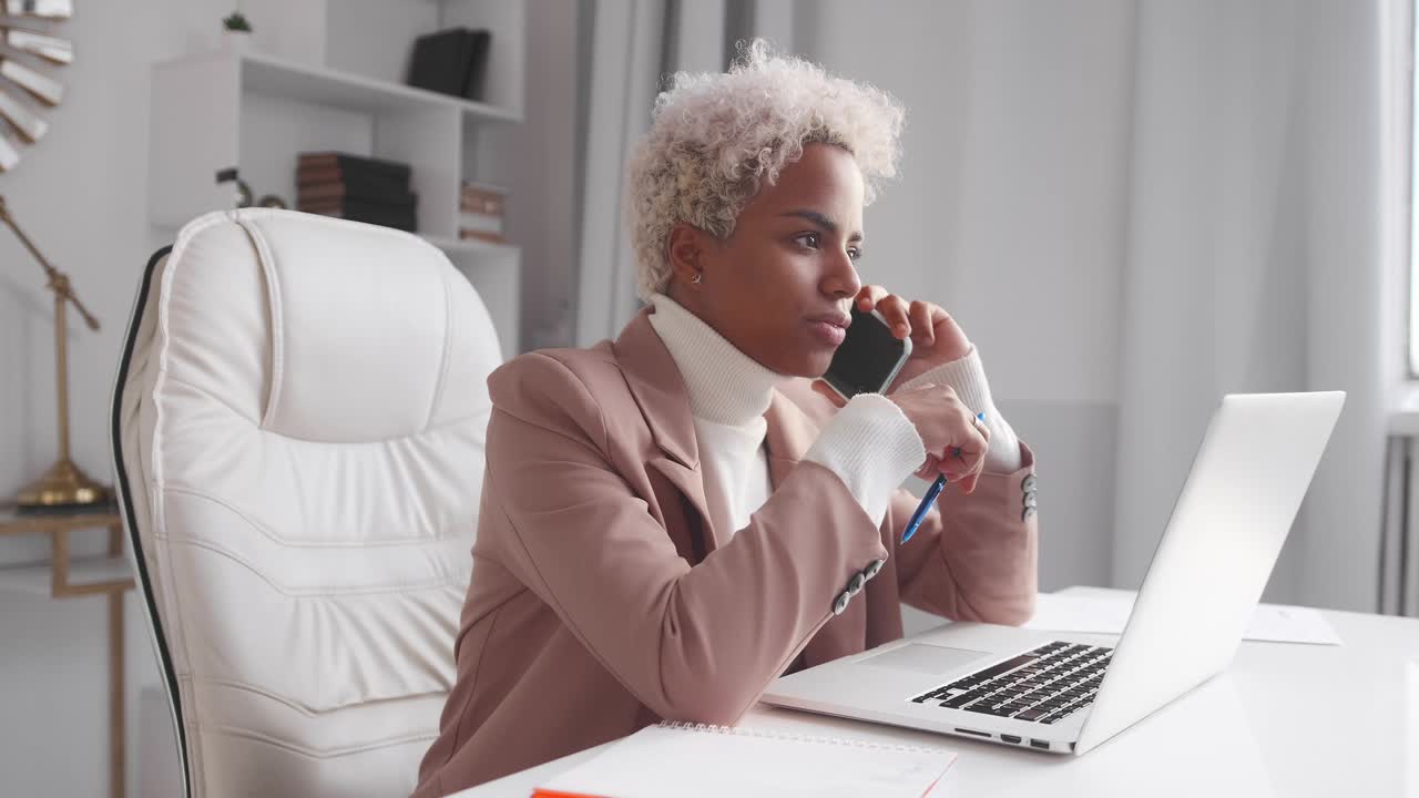 Young african american woman manager talking on phone with business partners
