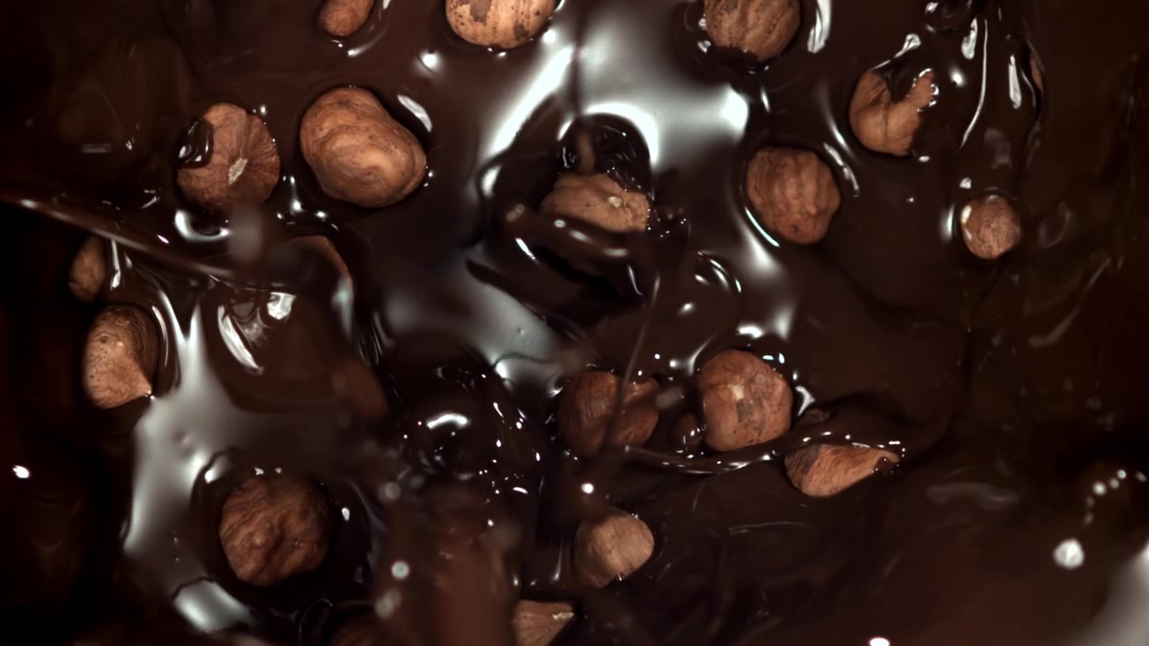 Chocolate Derretido Derramando Sobre Avelãs em Câmera Lenta