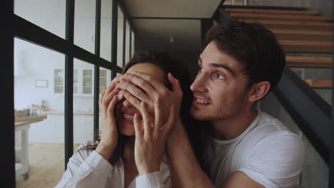 Happy-family-couple-entering-home-in-slow-motion.-Portrait-of-hugging-couple