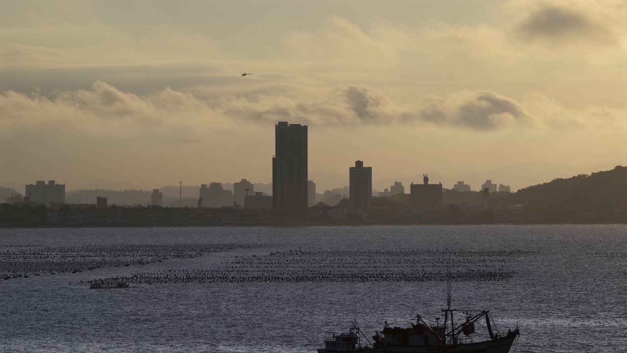 Sunset helicopter view over sea with Penha skyline and silhouette in Santa Catarina, Brazil
