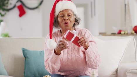 Glückliche-ältere-Afroamerikanische-Frau-Mit-Weihnachtsmannmütze,-Die-Zu-Weihnachten-Einen-Videoanruf-Führt