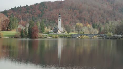 Tight-shot-of-Lake-Bohinj-church-with-a-perfect-still-reflection