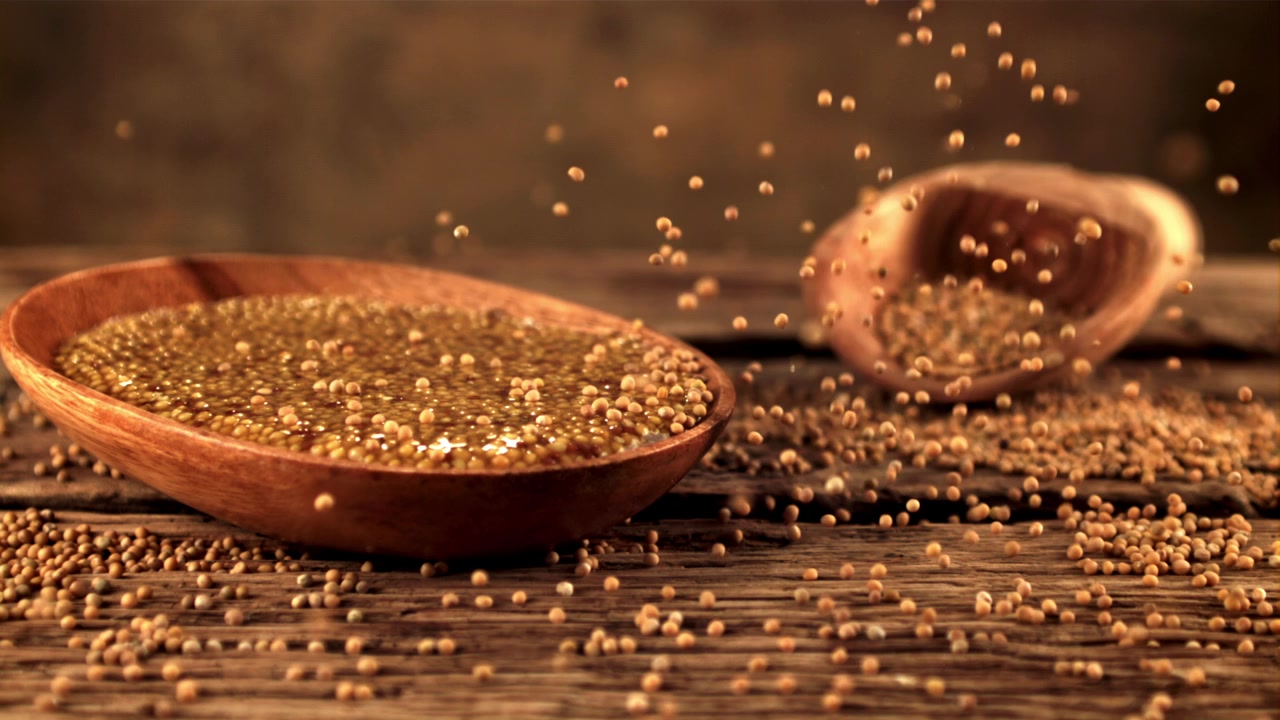 Slow Motion of Mustard Seeds Falling on a Rustic Wooden Table
