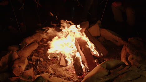 Campers-sitting-around-large-campfire-in-stone-ring