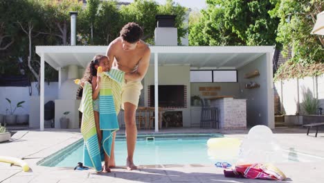 Happy-biracial-father-and-daughter-spending-time-at-pool-together