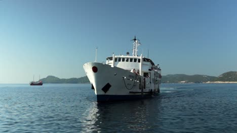 un gran ferry se acerca al puerto en un hermoso día soleado