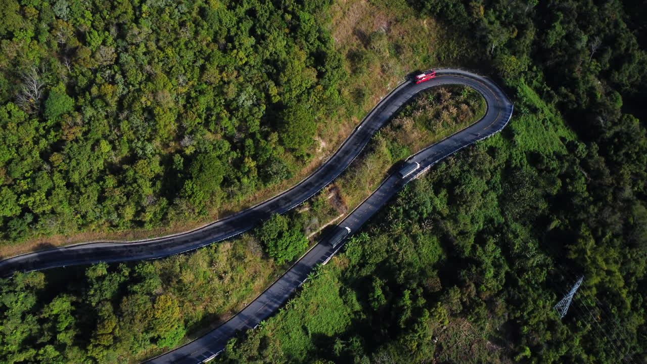 carretera asfaltada con curvas que conduce a la montaña del bosque de la selva con coches de conducción, vista aérea