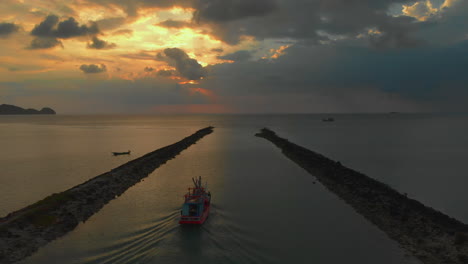 Following-fisherman-boat-goes-to-the-sea-against-sunset