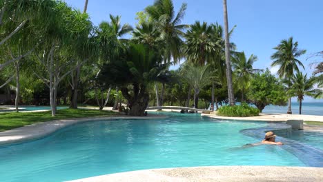 Tourists-Enjoying-The-Summer-At-The-Cozy-Outdoor-Pool-In-Dos-Palmos-Island-Resort-In-Puerto-Princesa,-Palawan,-Philippines---Medium-Shot