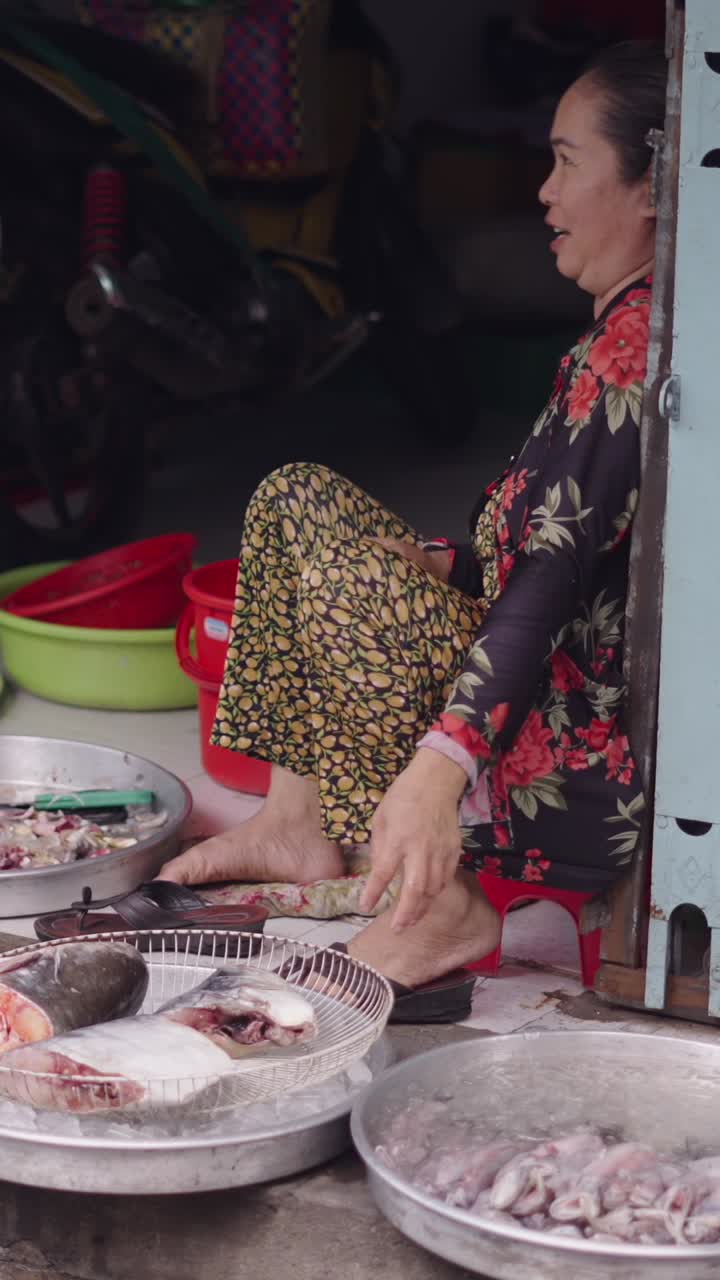 Woman selling fish and squid at a local market
