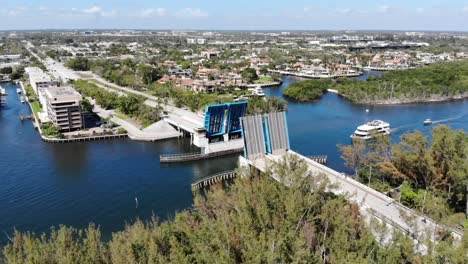 aerial shot moving along a bridge that has opened to let a large yacht pass through