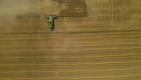 harvesting machine moving around the field in kielno poland during daytime - aerial shot