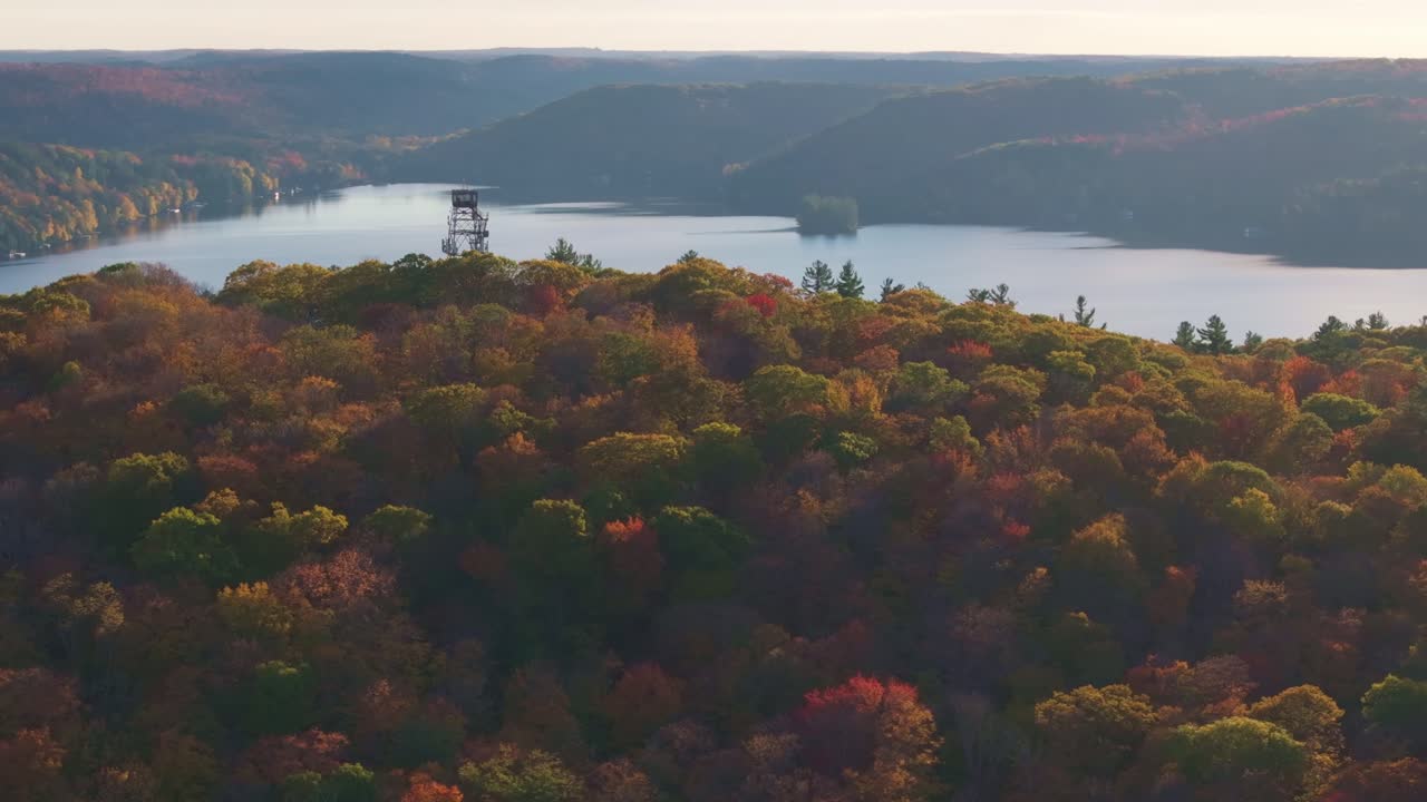 Dorset Lookout Tower overlooks a vibrant autumn forest and lake in Ontario, Canada, aerial view