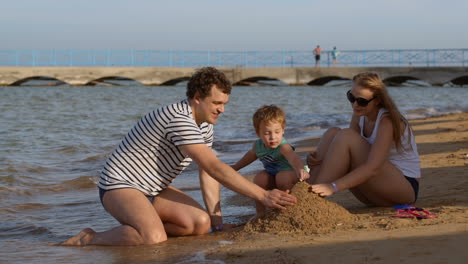 Familia-Haciendo-Un-Castillo-De-Arena