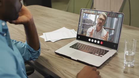 African-american-man-using-laptop-for-video-call,-with-business-colleague-on-screen