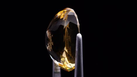 natural yellow citrine in the tweezer on the turning table