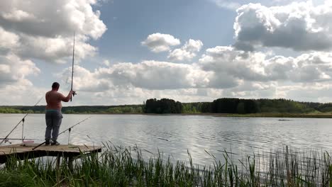 fisherman stand on wooden pier near lake with ripple water during cloudy day