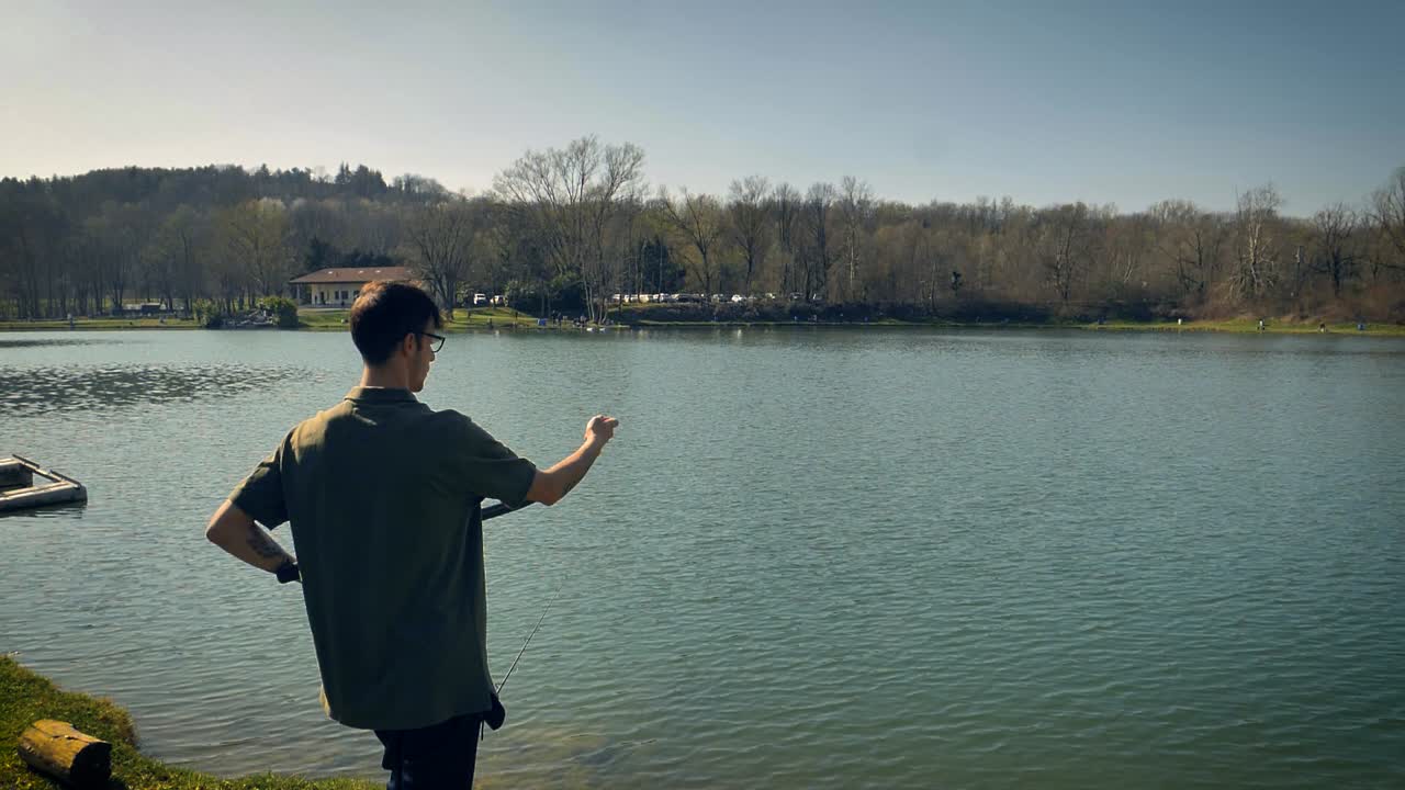 잉어-1을 유인하기 위해 물에 미끼를 던지는 도구를 사용하는 사람의 슬로우 모션 보기