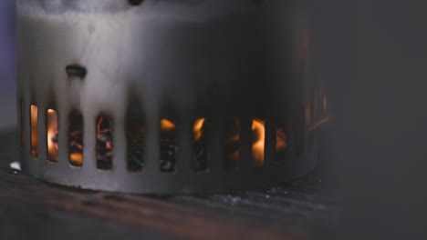 charcoal chimney starter heating up and flaming on a grill at a barbecue in a public park in summer