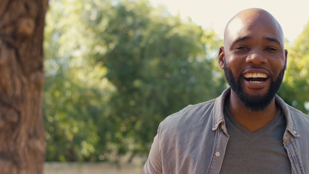 Portrait Of Laughing Man Standing Outdoors In Garden Park Or Countryside