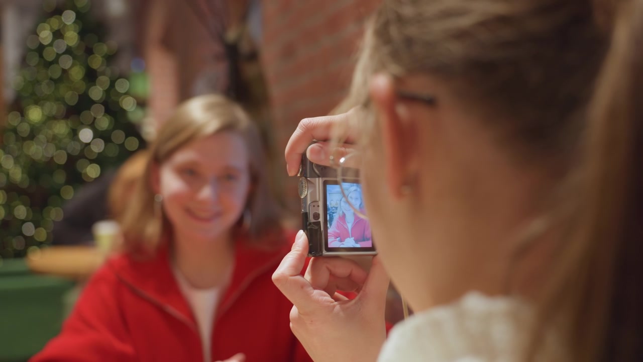 Young Woman Taking Photo of Her Friend with a Digital Camera