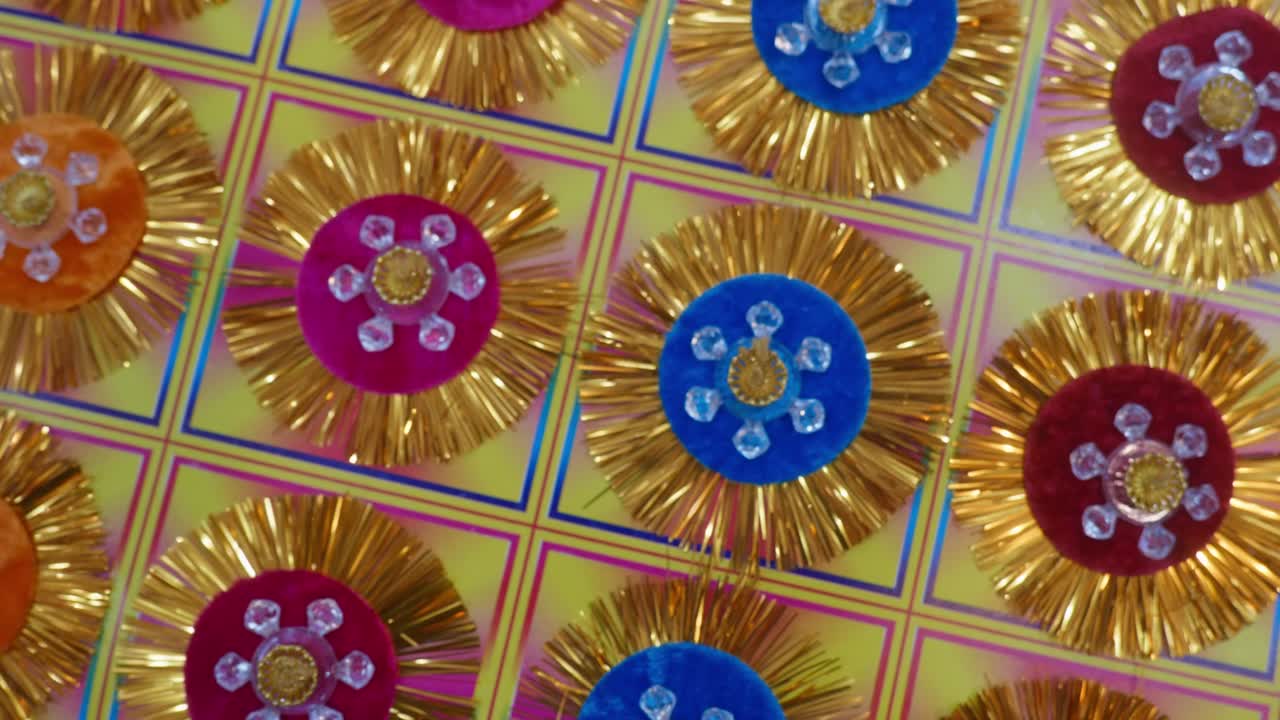 vibrant grid of handcrafted Flower-Shaped Rakhis, with shimmering gold tinsel, and colorful velvet base, for Raksha Bandhan Festival in India , 4k, parallax, push in, closeup, 25p