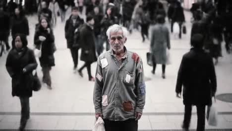 a solitary man in a tattered shirt holds a bag while surrounded by bustling pedestrians in an urban setting. this captures the stark contrast of isolation amid a crowd during the day.