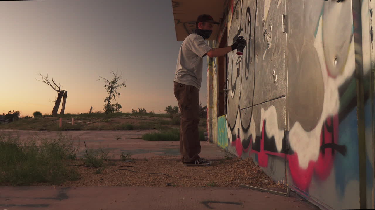 Artista de graffiti ao pôr-do-sol