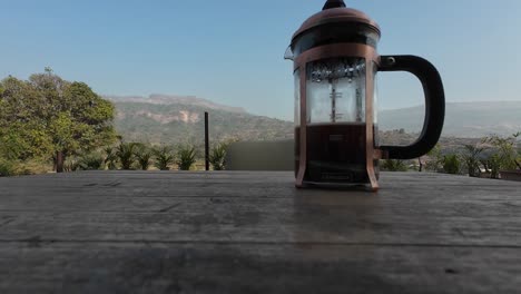 beber café en un paisaje con prensa francesa, montañas, paisaje en el fondo, café negro, café espresso, vacaciones, aire bnb, vacaciones, en el café de jardín