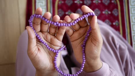 close-up of purple prayer beads on a prayer rug