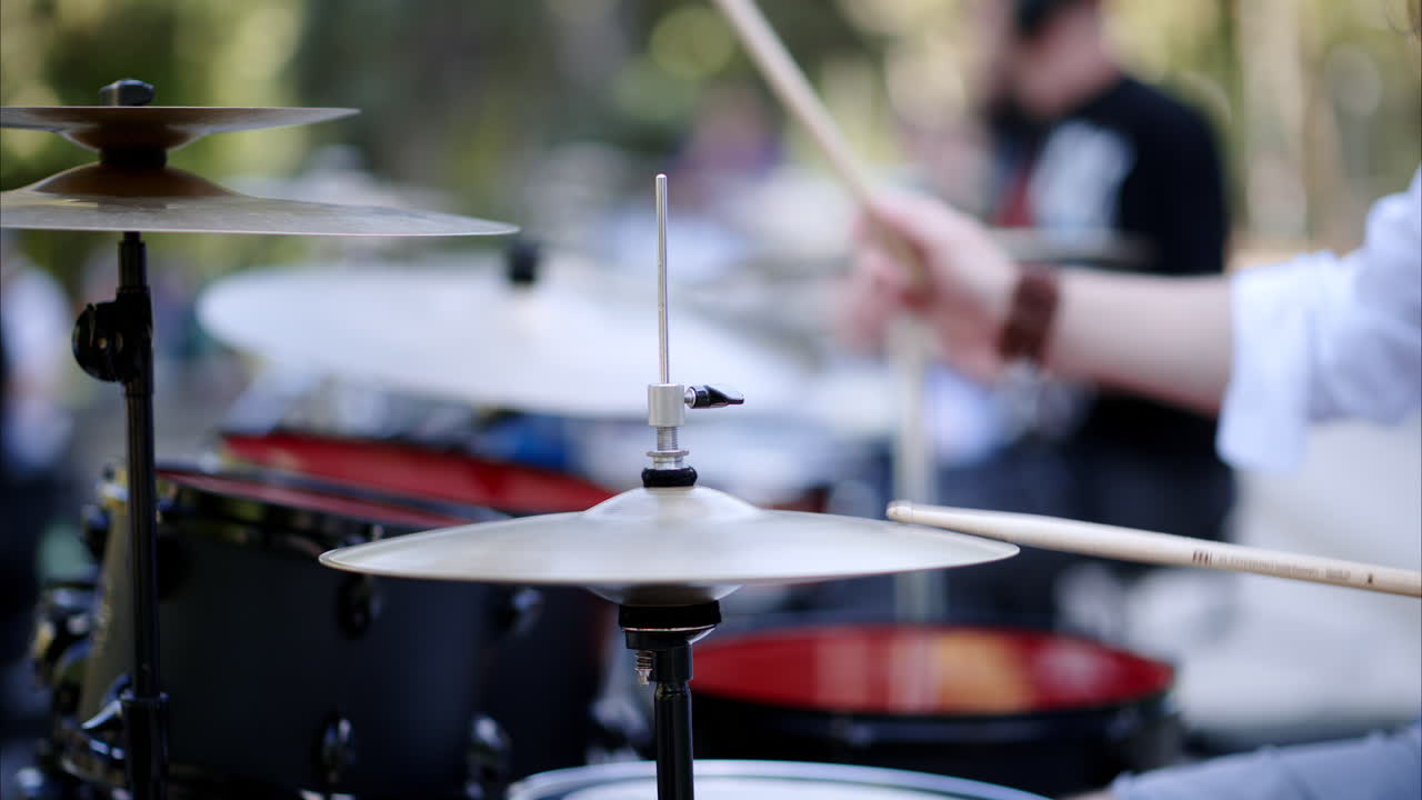 Close up of man playing red drums outside