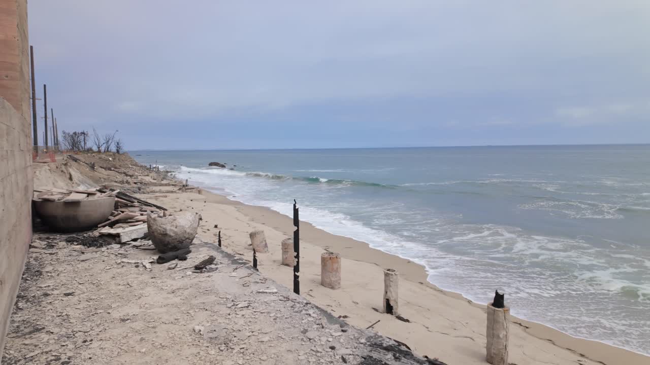 Gimbal dolly shot revealing beachfront homes burned by the Palisades Fire along Pacific Coast Highway in Malibu, California. 4K